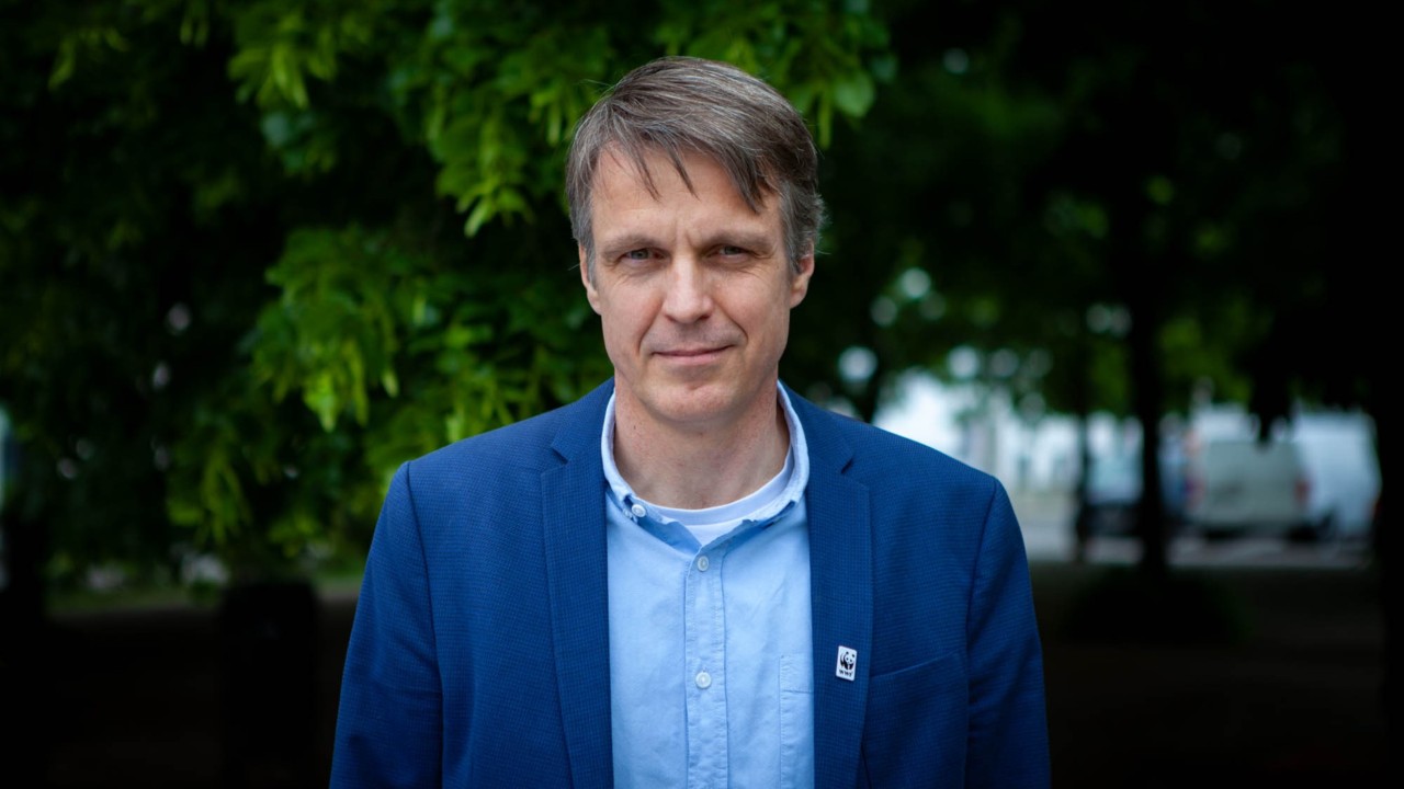 Rolf Sommer vom WWF steht vor einem grünen Baum