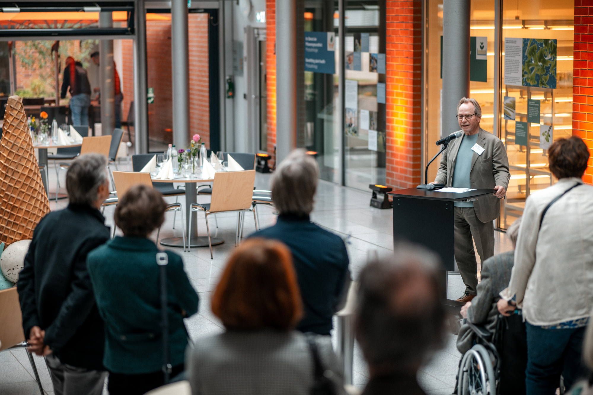 Besucher hören der Eröffnungsrede zu