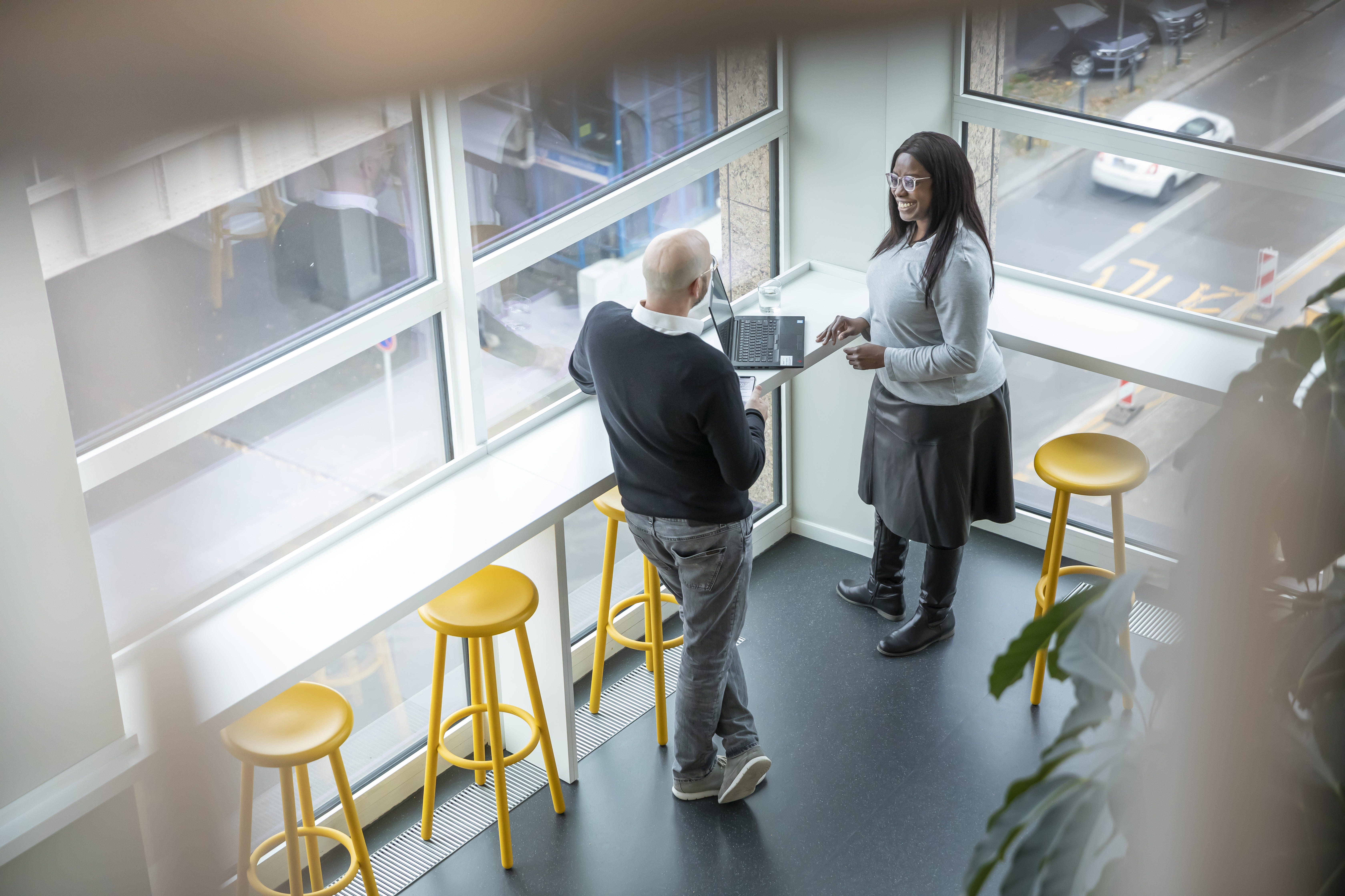 Zwei Angestellte stehen und diskutieren in einem Bürobereich