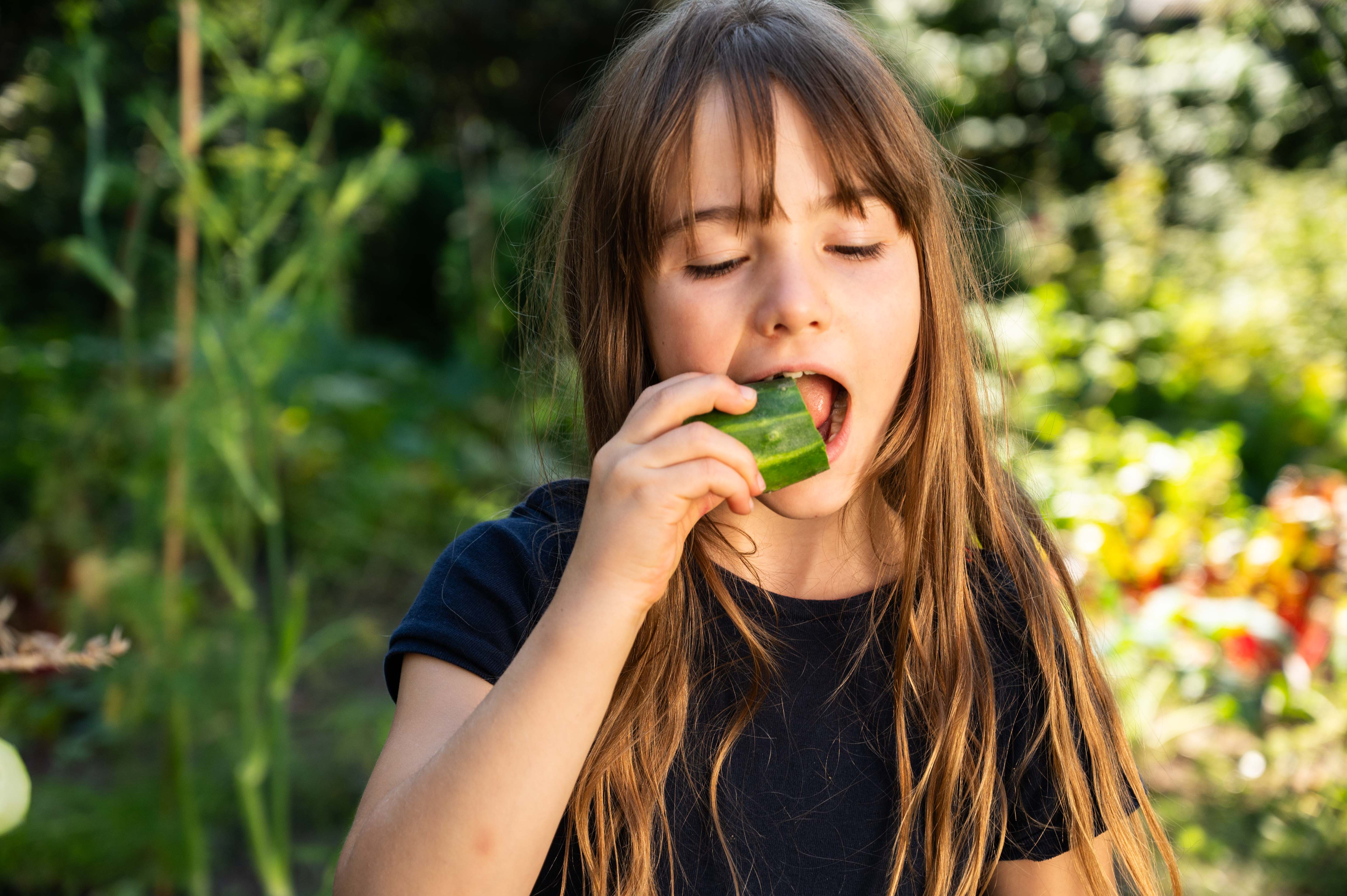 Female student biting into a cucumber