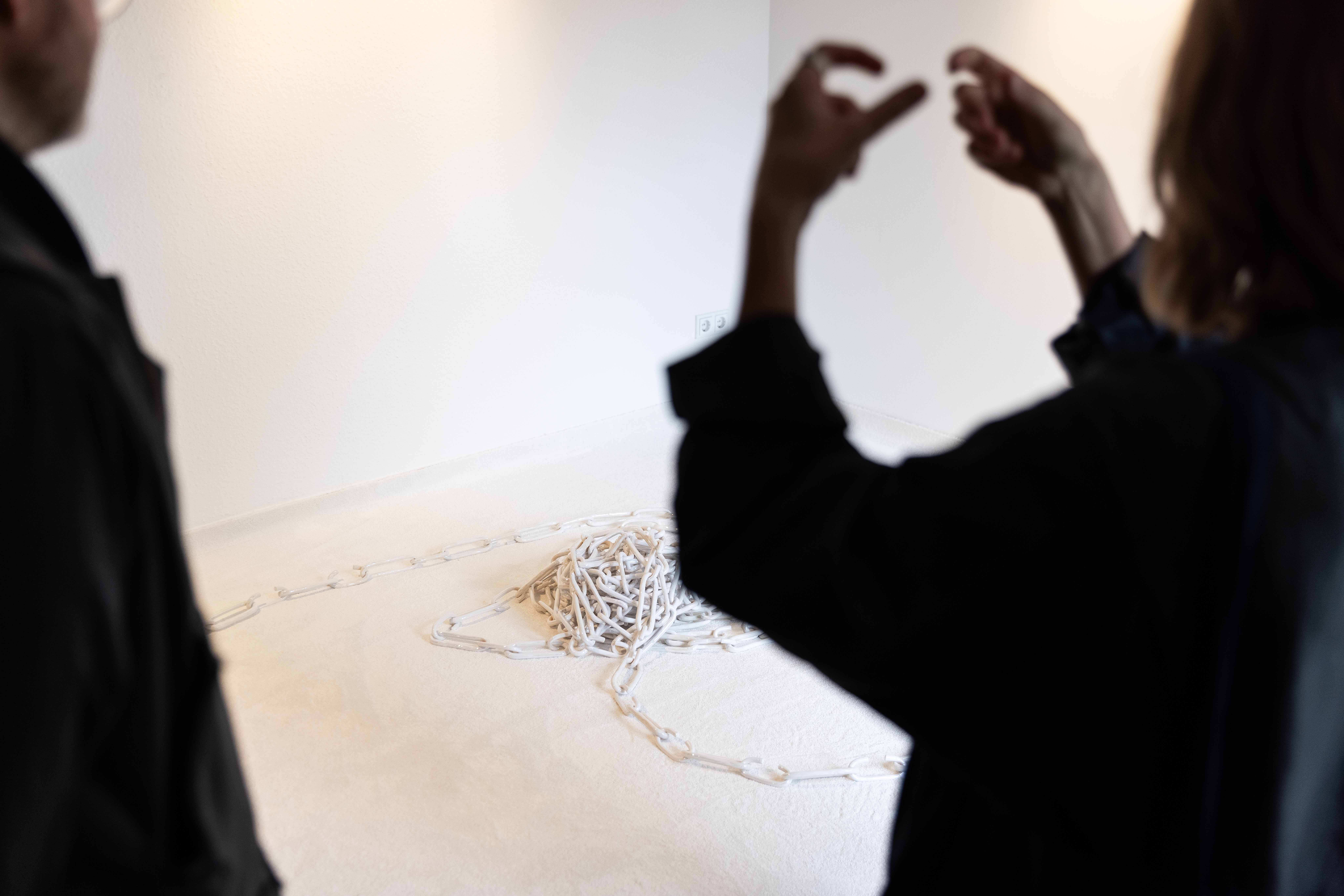 Constanze Böhm explains the creative process of her work &#34;rest in pieces&#34;, a ceramic work with around 250 chain links and special glazes. Image author: Andre Germar