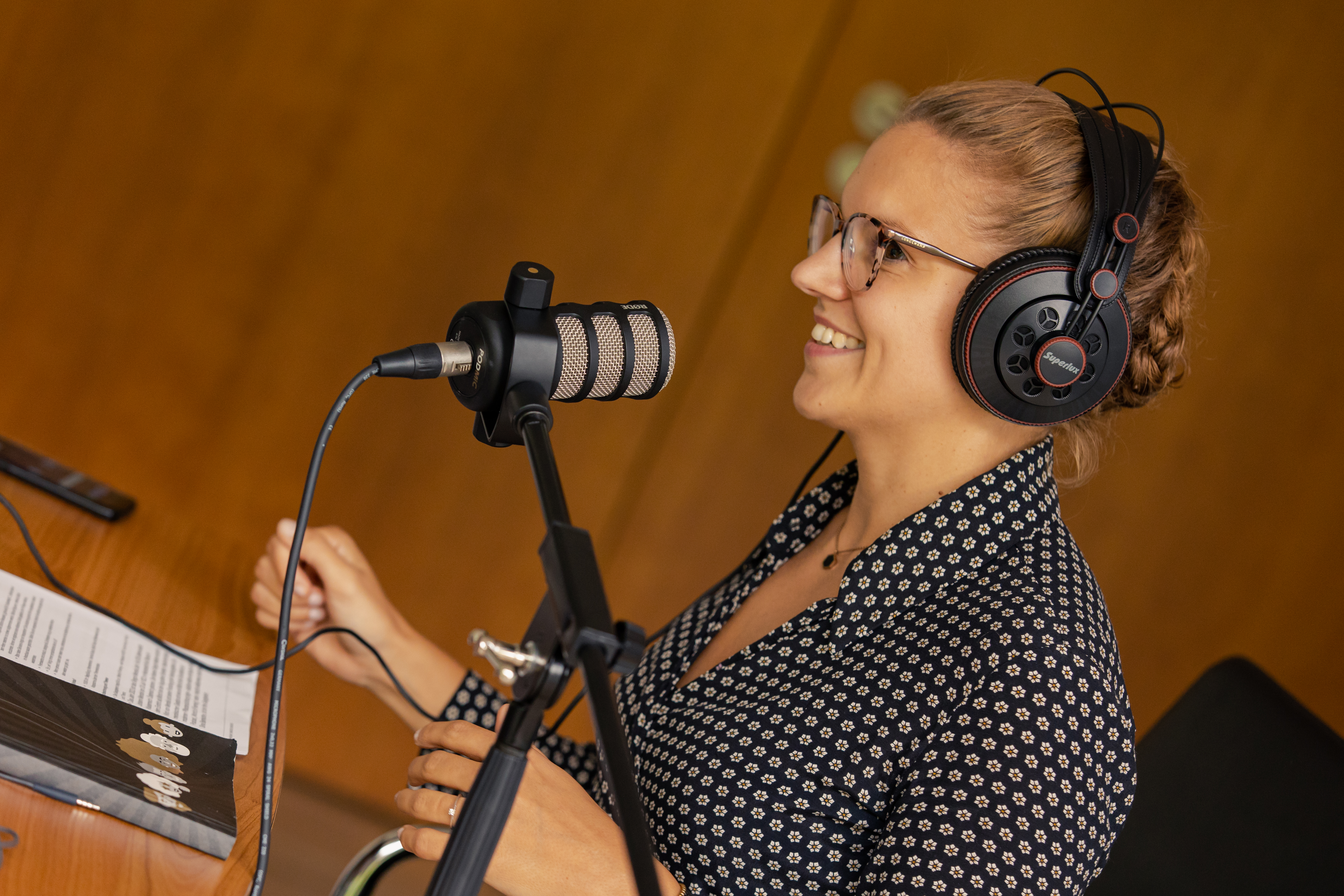 Frau mit Kopfhörer und Mikrofon im Studio