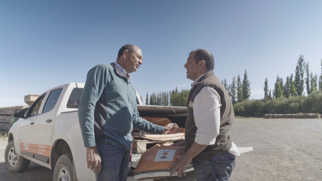 Bauer Luís Parra steht mit KWS Berater Alfonso Caligari vor einem Pickup auf dem Saatgut ist.