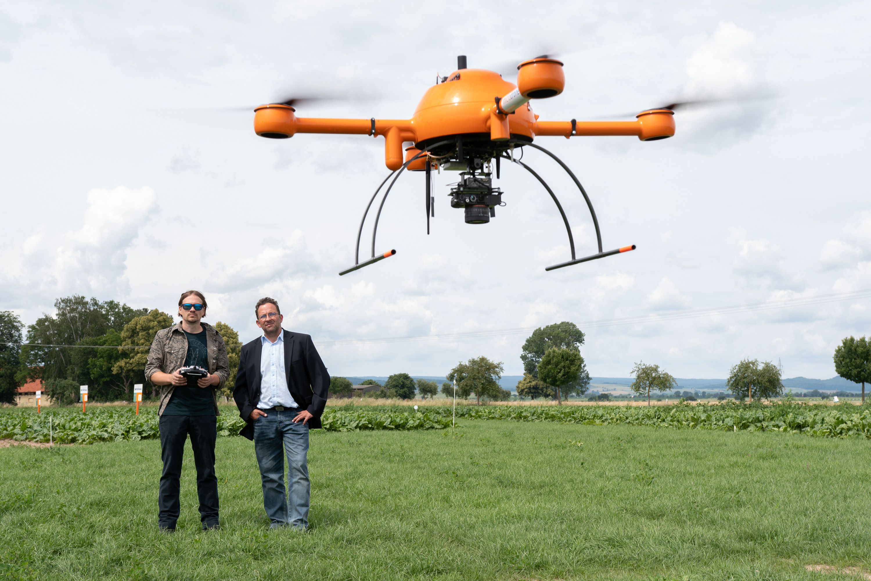 Christoph Bauer und Marius Burkhardt steuern eine Drohne über ein KWS-Versuchsfeld