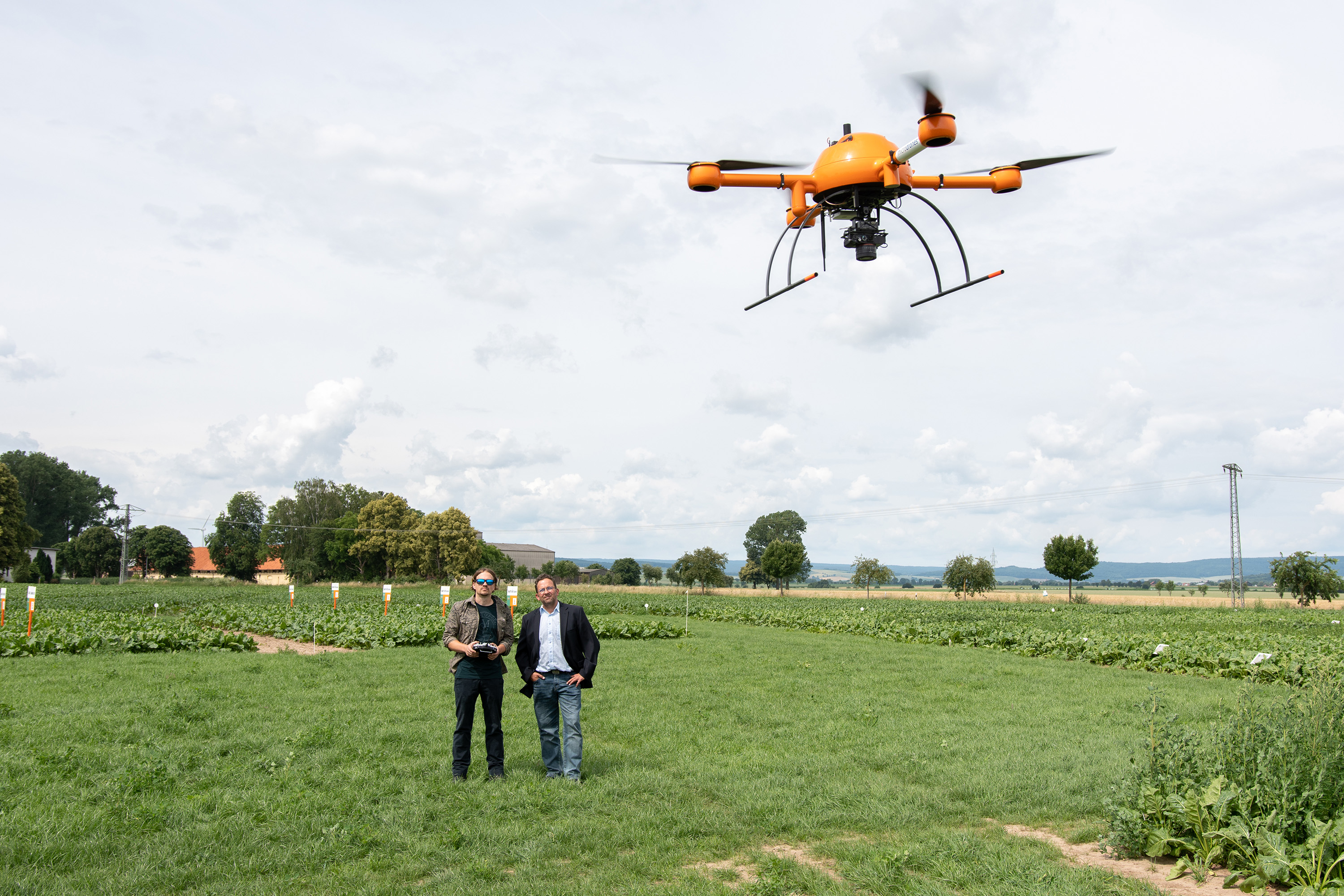 Christoph Bauer und Marius Burkhardt steuern eine Drohne über ein KWS-Versuchsfeld