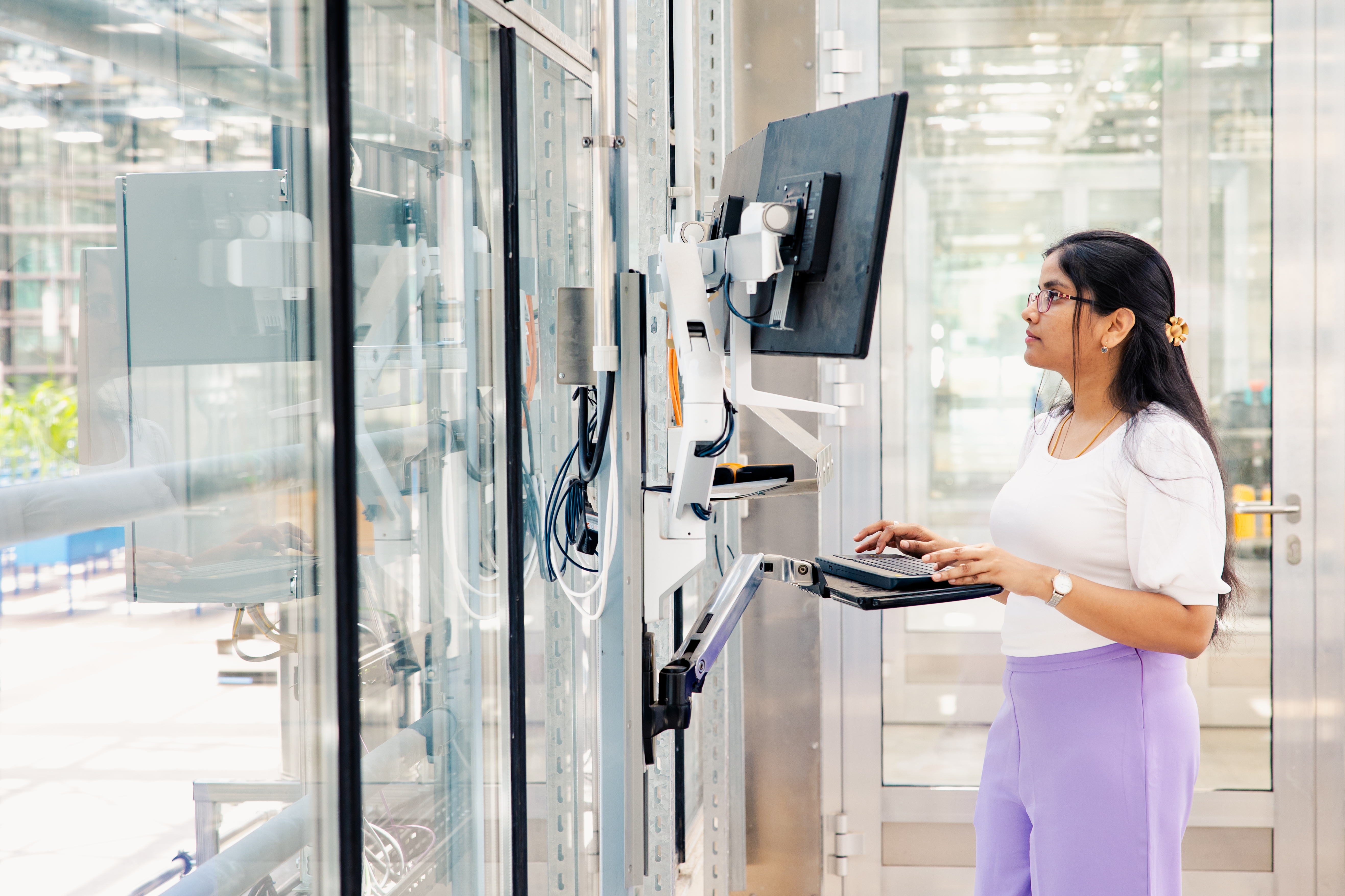 Een jonge IT-specialist die code bespreekt voor een groot scherm