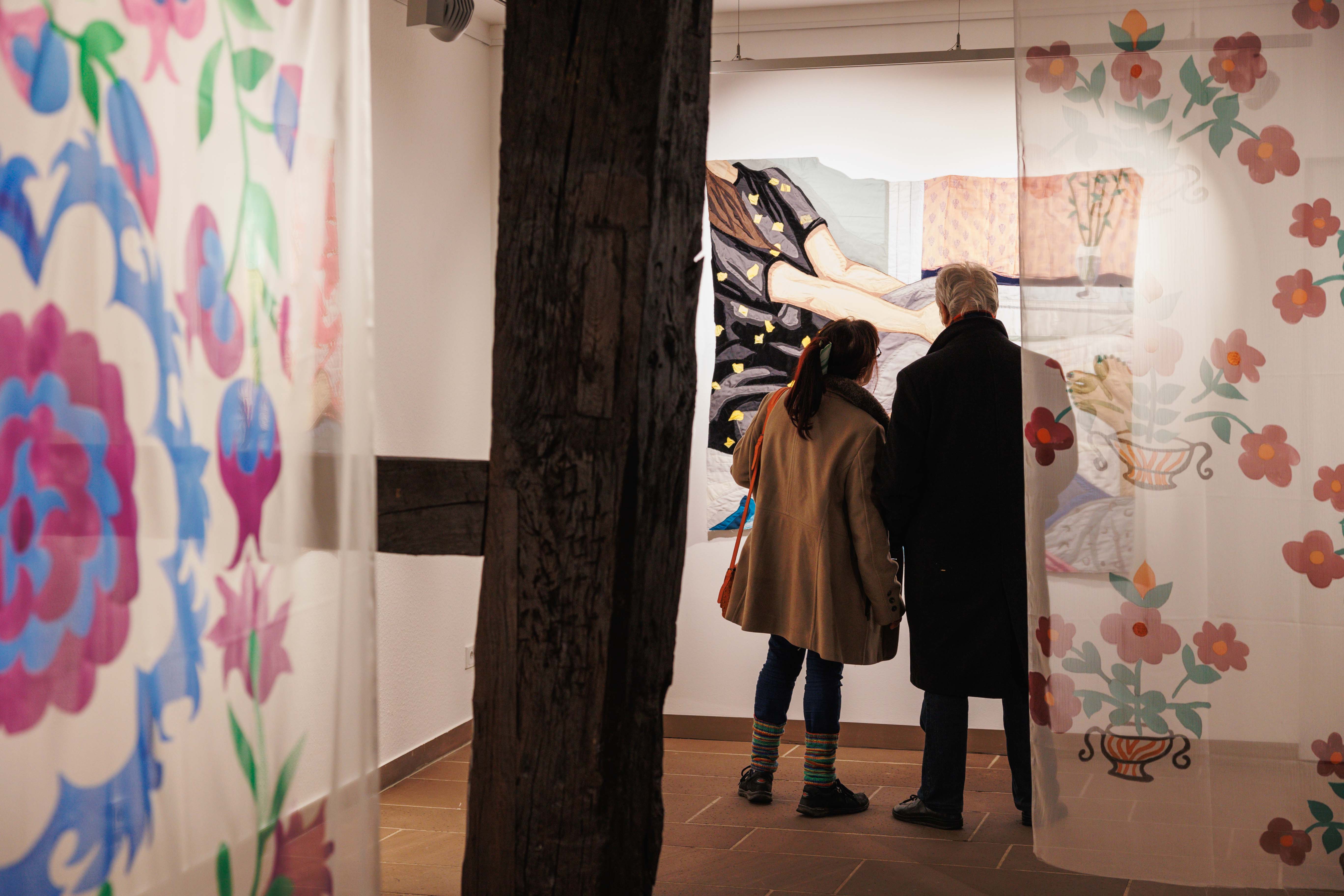 Two visitors in front of works by Hangama Amiri at the opening